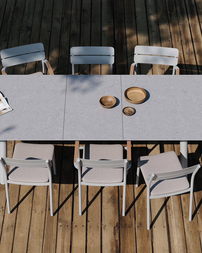 Outdoor dining set from Royal Garden with a large gray table and multiple chairs on a wooden deck.