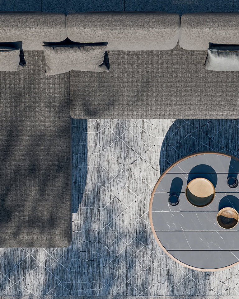 Top-down view of a modern, L-shaped outdoor sofa set with a round coffee table. 