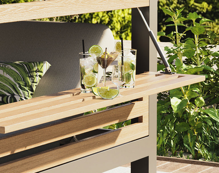Outdoor setting with a wooden table, cushions, and cocktails on a patio.